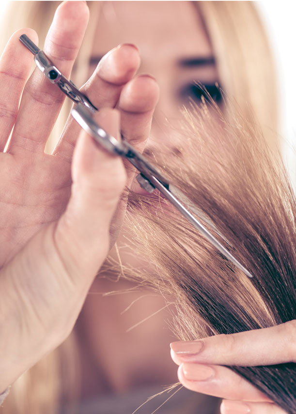 girl with hair cutting scissors cutting ends of hair