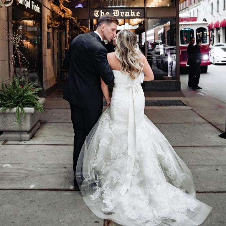 Bride and Groom kissing on a sidewalk downtown