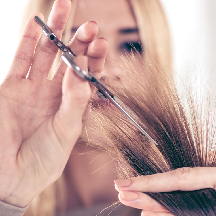 Woman trimming ends of blonde hair