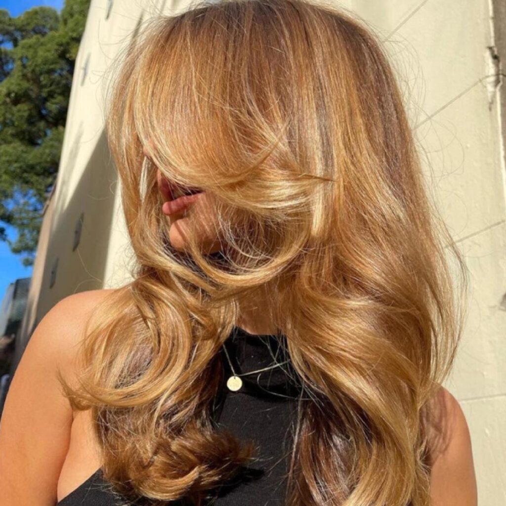 A woman with red-blonde bouncy waves