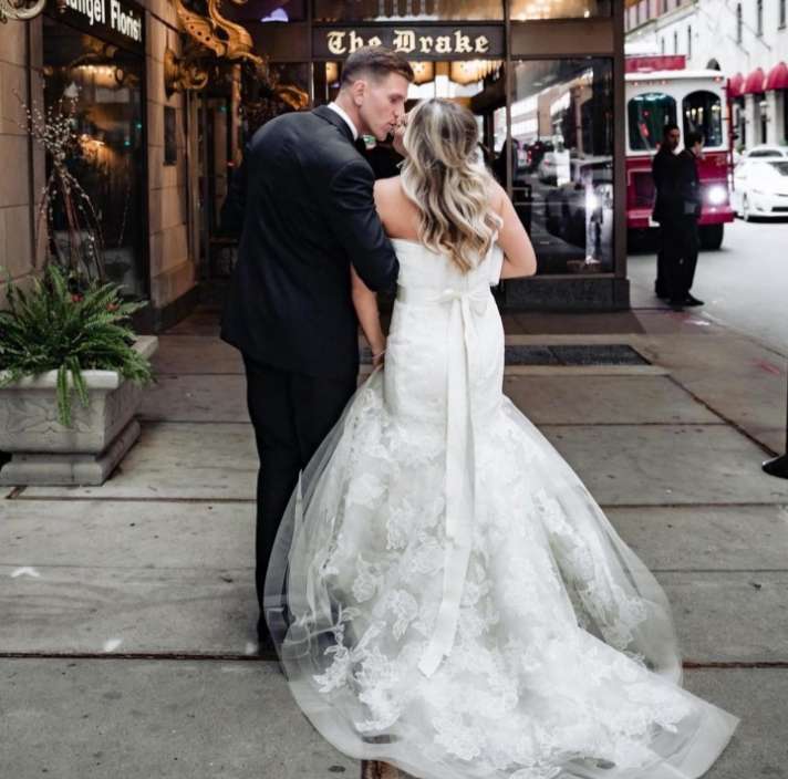 Summer wedding bride and groom share a kiss outside of the The Drake downtown Chicago.