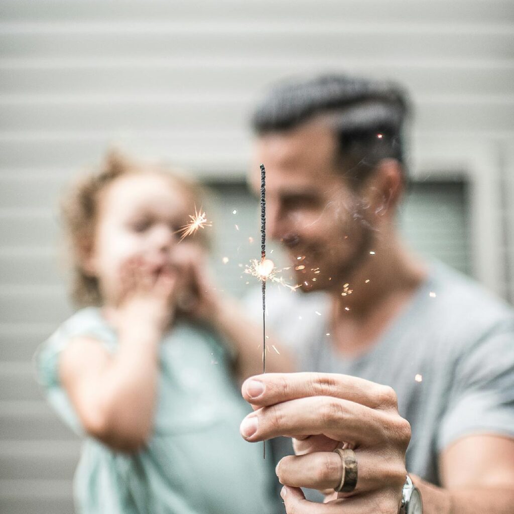 A father and his toddler daughter with a sparkler