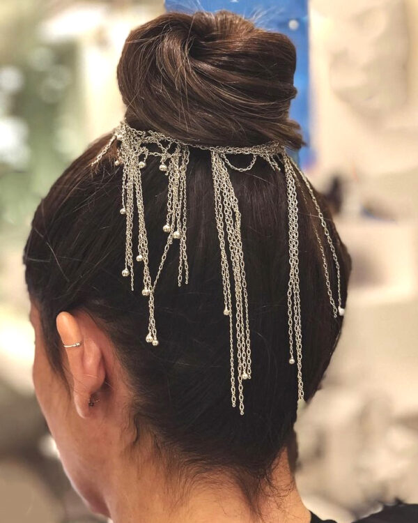 Bridal updo with silver chain accessory.